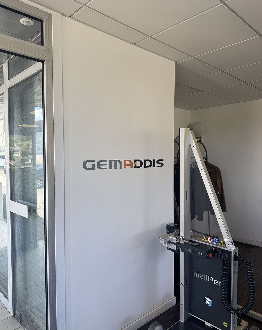 Logo Gemaddis imprimé sur un mur de bureau
